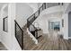 Bright foyer with modern staircase, wood floors, and stylish console table with decorative mirror at 18429 W Mauna Loa Ln, Surprise, AZ 85388