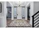 Elegant foyer with coffered ceilings, modern lighting, a front door and beautiful floors at 18429 W Mauna Loa Ln, Surprise, AZ 85388