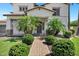 Beautiful home featuring mature palm trees, manicured landscaping, and a brick walkway at 18429 W Mauna Loa Ln, Surprise, AZ 85388