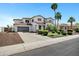 Charming two-story home with landscaped yard, palm trees, and a three car garage at 18429 W Mauna Loa Ln, Surprise, AZ 85388