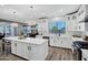 A modern kitchen featuring white cabinets, stainless steel appliances, a central island, and contemporary lighting at 18429 W Mauna Loa Ln, Surprise, AZ 85388