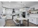 A spacious kitchen featuring white cabinets, stainless steel appliances, a large island, and modern light fixtures at 18429 W Mauna Loa Ln, Surprise, AZ 85388