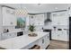 A well-appointed kitchen featuring white cabinets, stainless steel appliances, a large island with seating, and modern lighting at 18429 W Mauna Loa Ln, Surprise, AZ 85388