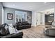 Open-concept living room with natural light, modern floors, and view into foyer and game room at 18429 W Mauna Loa Ln, Surprise, AZ 85388