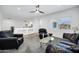 Bright living room featuring a ceiling fan, plush seating and a glass coffee table at 18429 W Mauna Loa Ln, Surprise, AZ 85388