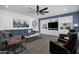 A cozy living room with built-in shelves, plush seating, modern decor, and a ceiling fan at 18429 W Mauna Loa Ln, Surprise, AZ 85388