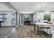 An open living space featuring a dining area, an island with bar stools, and sliding glass doors leading to the outdoor pool at 18429 W Mauna Loa Ln, Surprise, AZ 85388
