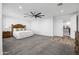 Bright main bedroom with plush carpeting, ceiling fan, and ensuite bathroom entrance at 18429 W Mauna Loa Ln, Surprise, AZ 85388