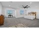 Spacious main bedroom features neutral carpet, ceiling fan, and a cozy sitting area with natural light at 18429 W Mauna Loa Ln, Surprise, AZ 85388