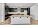 Modern kitchen featuring dark cabinets, granite countertops, stainless steel appliances and island with sink at 18950 W Stella Ave, Waddell, AZ 85355