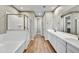 A well-lit bathroom with a double vanity, a soaking tub, and a glass-enclosed shower at 19026 W Stella Ave, Waddell, AZ 85355