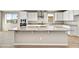 A kitchen island with white cabinets, stainless steel appliances, and a granite countertop at 19026 W Stella Ave, Waddell, AZ 85355