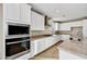 A modern kitchen featuring white cabinets, granite countertops, stainless appliances, and wood flooring at 19026 W Stella Ave, Waddell, AZ 85355
