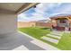 Wide view of a backyard with artificial turf, pavers, a swing set, and a gazebo-like lounge area at 19407 W Pierson St, Litchfield Park, AZ 85340