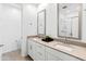 Bright bathroom with dual sinks, quartz countertops, and tiled shower at 19407 W Pierson St, Litchfield Park, AZ 85340