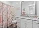 Bright bathroom with modern vanity, neutral countertop, and shower with stylish, marbled shower curtain at 19407 W Pierson St, Litchfield Park, AZ 85340