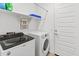 Well-lit laundry room features a washer, dryer, shelving, and door to the side yard at 19407 W Pierson St, Litchfield Park, AZ 85340
