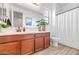 Bright bathroom featuring wood-grain tile floors, wood vanity, and white countertops, offering a clean and modern design at 19806 W Marshall Ave, Litchfield Park, AZ 85340