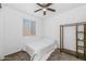 Simple bedroom with a single bed, ceiling fan, and a bright window, creating a serene space at 19806 W Marshall Ave, Litchfield Park, AZ 85340