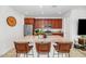 Well-lit kitchen boasts granite counters, stainless appliances, and an island with barstool seating at 19806 W Marshall Ave, Litchfield Park, AZ 85340