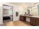 Neutral bathroom with a double sink vanity, framed mirror, and views into bedroom at 21648 W Ashleigh Marie St, Buckeye, AZ 85326