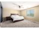 Cozy bedroom featuring carpeted floors, a fan, and a window allowing natural light at 21648 W Ashleigh Marie St, Buckeye, AZ 85326