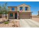 Two-story home with tan stucco, blue shutters, landscaping and an American flag at 21648 W Ashleigh Marie St, Buckeye, AZ 85326