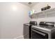 Laundry room featuring front load washer and dryer and shelving at 21648 W Ashleigh Marie St, Buckeye, AZ 85326