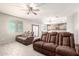 Spacious living room with a ceiling fan, wood-look floors, and lots of natural light at 21648 W Ashleigh Marie St, Buckeye, AZ 85326