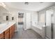 Bathroom featuring a bathtub, shower, sink with a wooden vanity, laminate flooring, and a door at 22926 W Yavapai St, Buckeye, AZ 85326