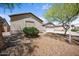 Beautiful exterior showcasing desert landscaping with a three car garage and a lush green bush at 22926 W Yavapai St, Buckeye, AZ 85326