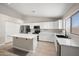 This kitchen showcases white cabinetry, stainless steel appliances, and an island with seating at 22926 W Yavapai St, Buckeye, AZ 85326