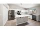 Modern kitchen featuring stainless steel appliances, white cabinets, an island, and light-colored laminate flooring at 22926 W Yavapai St, Buckeye, AZ 85326