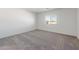 A bedroom with neutral carpet, a window with blinds, and simple white walls at 25138 W Chanute Pass, Buckeye, AZ 85326