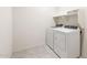 Laundry room features tile floors and white washer and dryer hookups at 25138 W Chanute Pass, Buckeye, AZ 85326