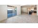 Open living space featuring sliding glass doors and tile flooring, leading to a kitchen with stainless steel appliances at 25138 W Chanute Pass, Buckeye, AZ 85326