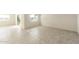 Bright, empty living area with tiled floors, large windows, and sliding glass doors for plenty of natural light at 25200 W Wier Ave, Buckeye, AZ 85326