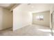 Open living room featuring tiled floors, a sliding glass door leading to the backyard, and a neutral color palette at 25200 W Wier Ave, Buckeye, AZ 85326