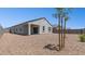 Home exterior with stucco, dark roof, rock landscaping, and a covered porch perfect for enjoying the outdoors at 25235 N 183Rd Dr, Wittmann, AZ 85361