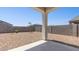 Enclosed backyard featuring gravel, cement porch, block wall, and young trees, creating a peaceful and private outdoor space at 25235 N 183Rd Dr, Wittmann, AZ 85361