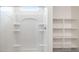 Bathroom features a shower with glass doors and a built in shelving unit at 25235 N 183Rd Dr, Wittmann, AZ 85361