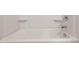 A clean, well-lit bathtub with integrated shelving and chrome fixtures at 25235 N 183Rd Dr, Wittmann, AZ 85361