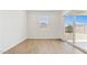 Well-lit bedroom with wood-look tile flooring and sliding glass door to backyard at 25235 N 183Rd Dr, Wittmann, AZ 85361