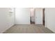 This bedroom features neutral carpet and a doorway leading to the bathroom with hard surface floors at 25235 N 183Rd Dr, Wittmann, AZ 85361