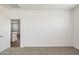 An airy bedroom looks out to a dining and kitchen space, with neutral carpet at 25235 N 183Rd Dr, Wittmann, AZ 85361
