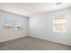 An airy bedroom with neutral carpet and two bright windows for natural light at 25235 N 183Rd Dr, Wittmann, AZ 85361