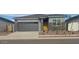 Charming single-story home featuring a gray exterior, gray garage door, and low maintenance landscaping at 25235 N 183Rd Dr, Wittmann, AZ 85361