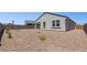 Home exterior with stucco, dark roof, rock landscaping, and double-pane windows, offering energy efficiency and modern appeal at 25235 N 183Rd Dr, Wittmann, AZ 85361