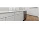 Elegant kitchen island with stainless steel dishwasher, white cabinets, and tile flooring at 25235 N 183Rd Dr, Wittmann, AZ 85361