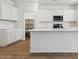 Close-up of modern kitchen with stainless steel appliances, sleek white cabinets, and a center island at 25235 N 183Rd Dr, Wittmann, AZ 85361